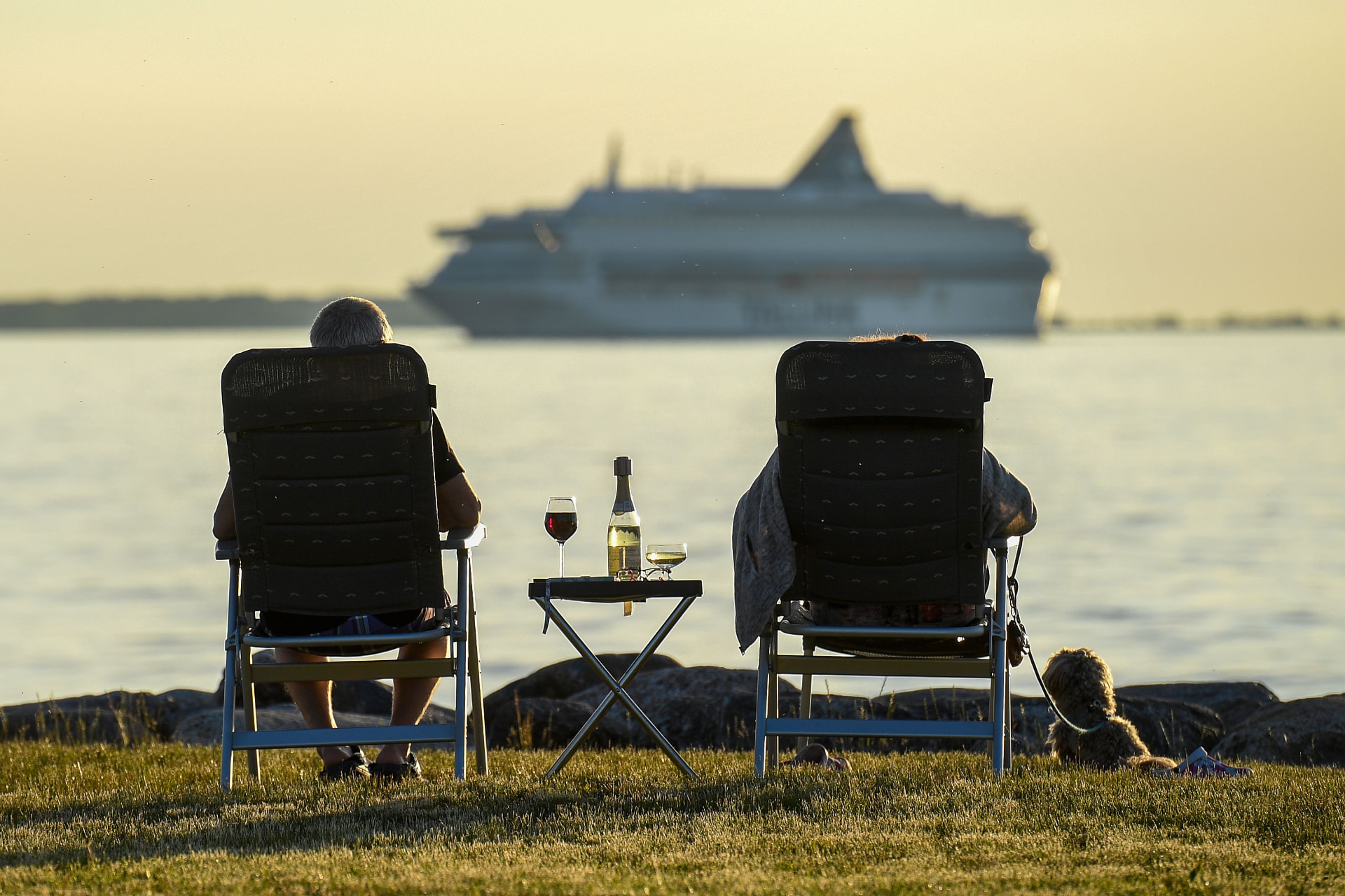 Ett par tar det lugnt i strandstolar och tittar ut över vattnet